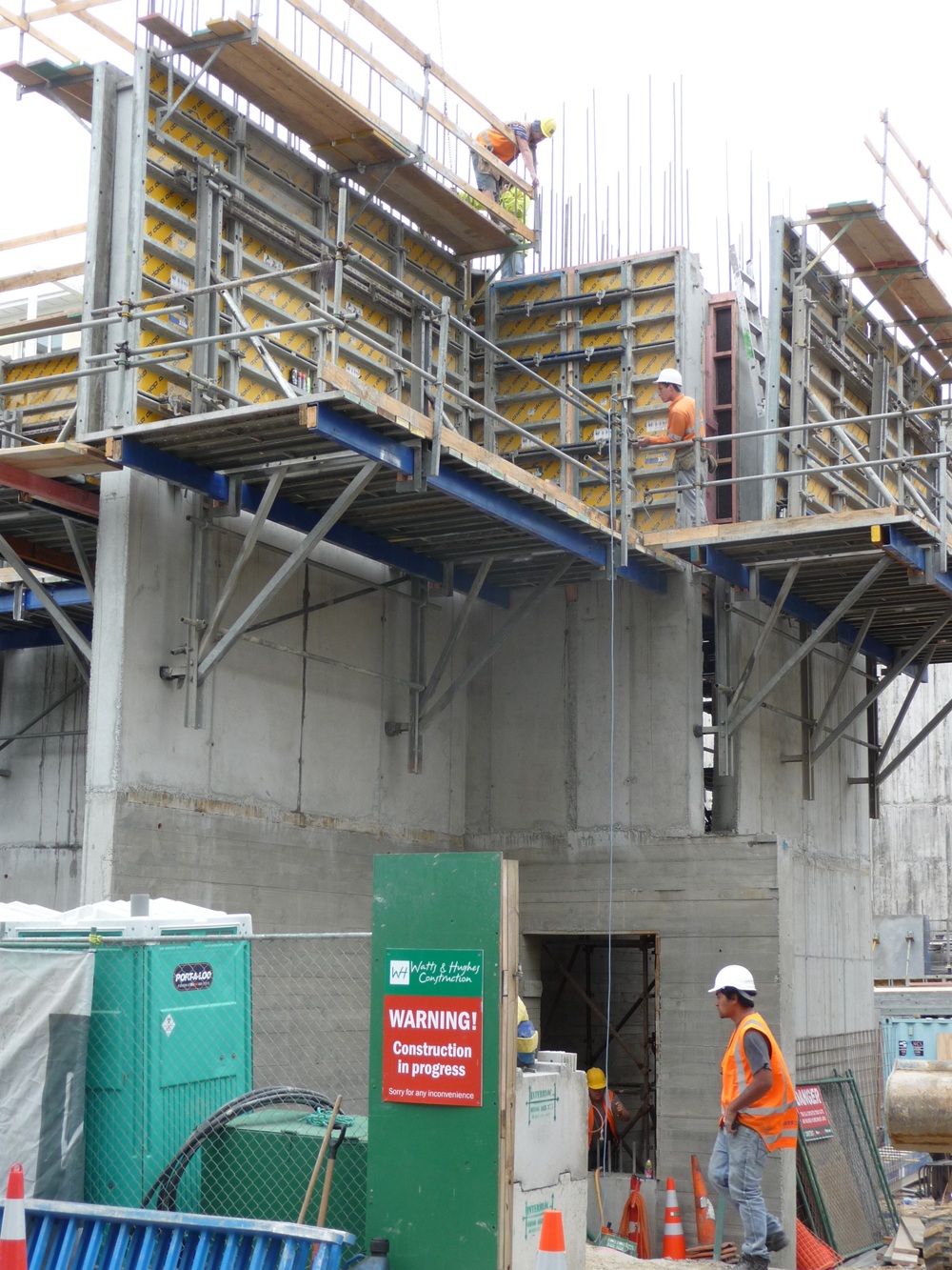 A person standing next to a buildingDescription automatically generated with low confidence